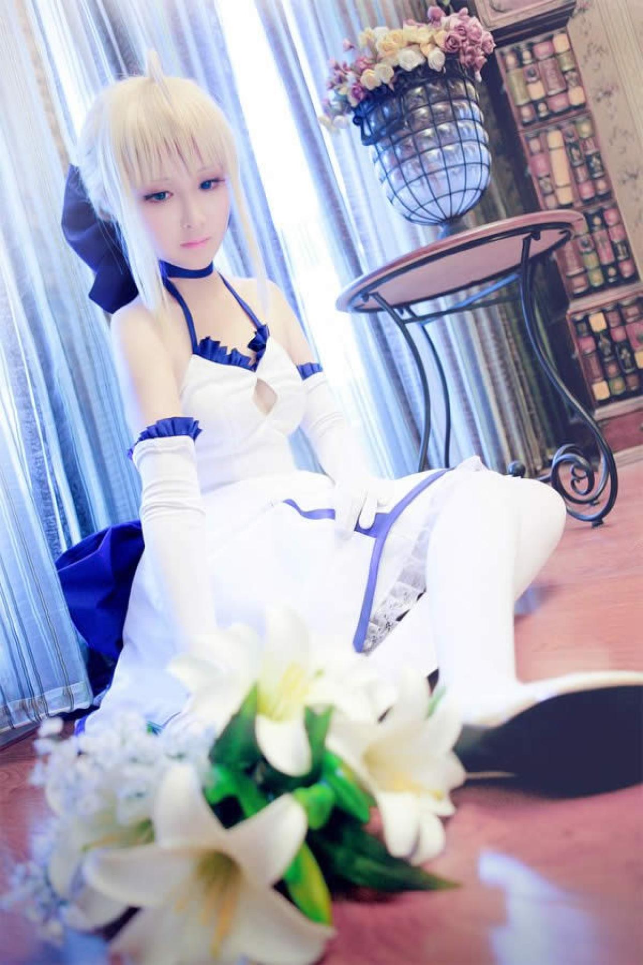 水水女剑士Cosplay蹲坐在地板上，鲜花搁在旁边，忧伤的样子