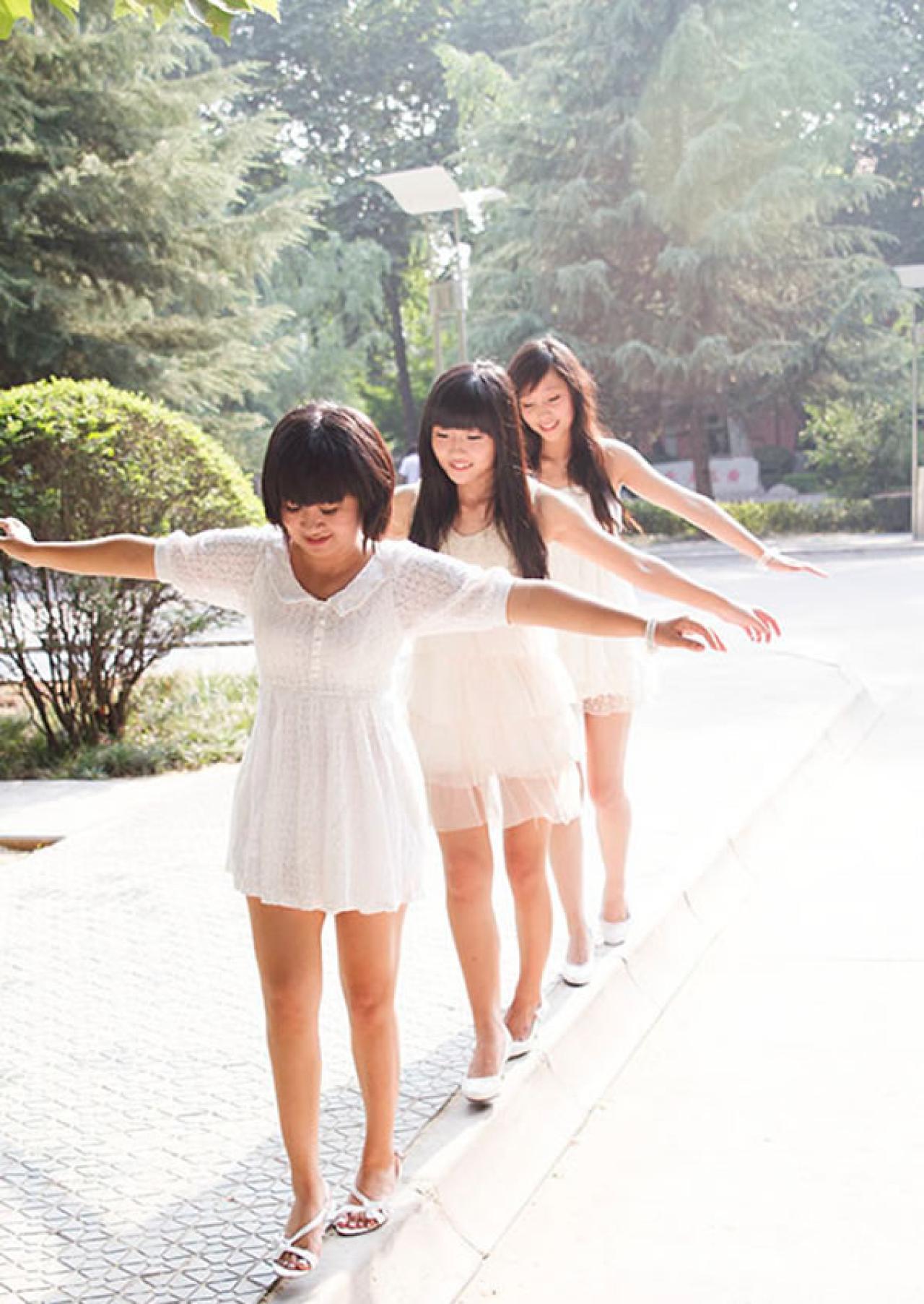 蕊蕊Thea姊妹写真集姐妹三人一起走马路旁的台阶，做平衡小心翼翼的姿势