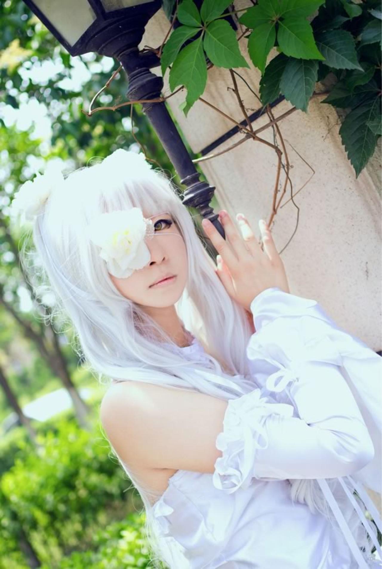 雪华绮晶身穿白色蓓蕾花苞裙扶着老式街灯站立