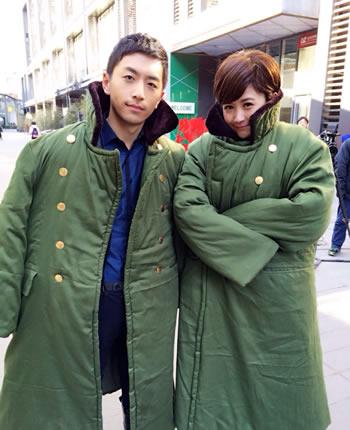 万万没想到小兵过年女主角汪聪和男主角白客身穿绿色军大衣驱逐寒冷，自嘲走在时尚的前沿