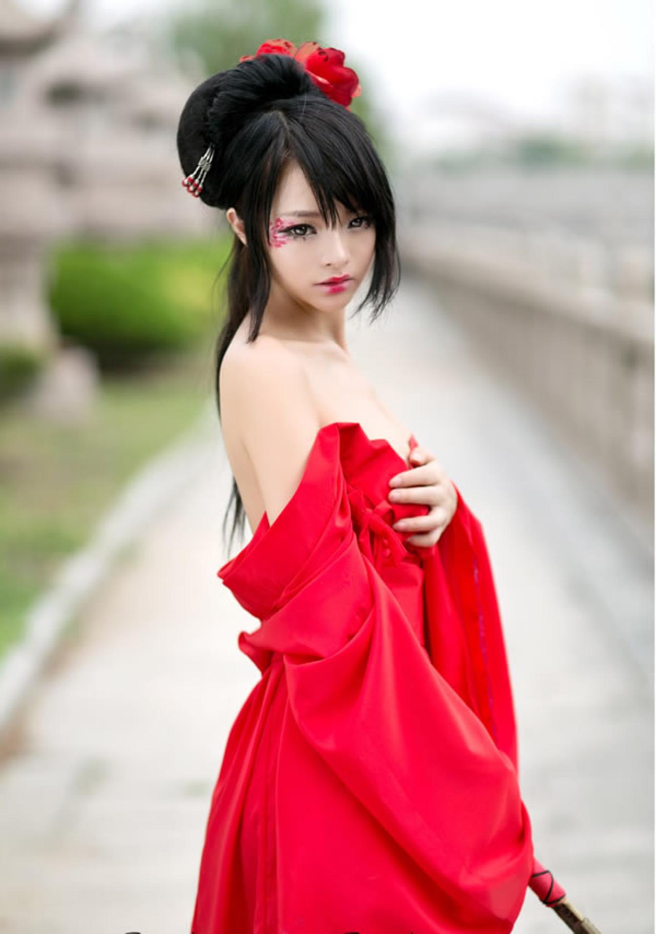 歪歪穿着大红色绸缎手持剑侧身照