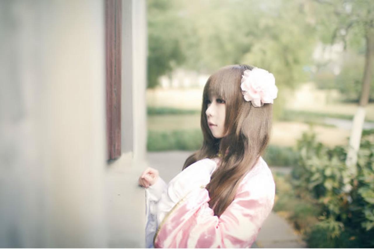 季_凋葬穿着粉衣扮演湾娘轻抚着胸口，透着石墙上的窗户的缝隙，向里紧张的看去