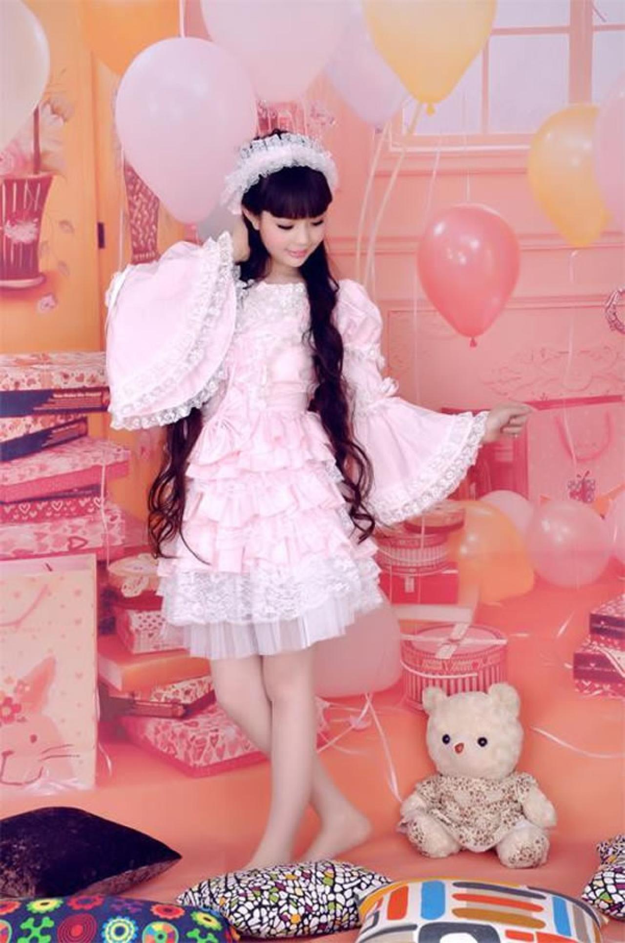 魔法少女大道寺知世穿着粉色公主裙两手交叉站立，扬起袖摆的样子