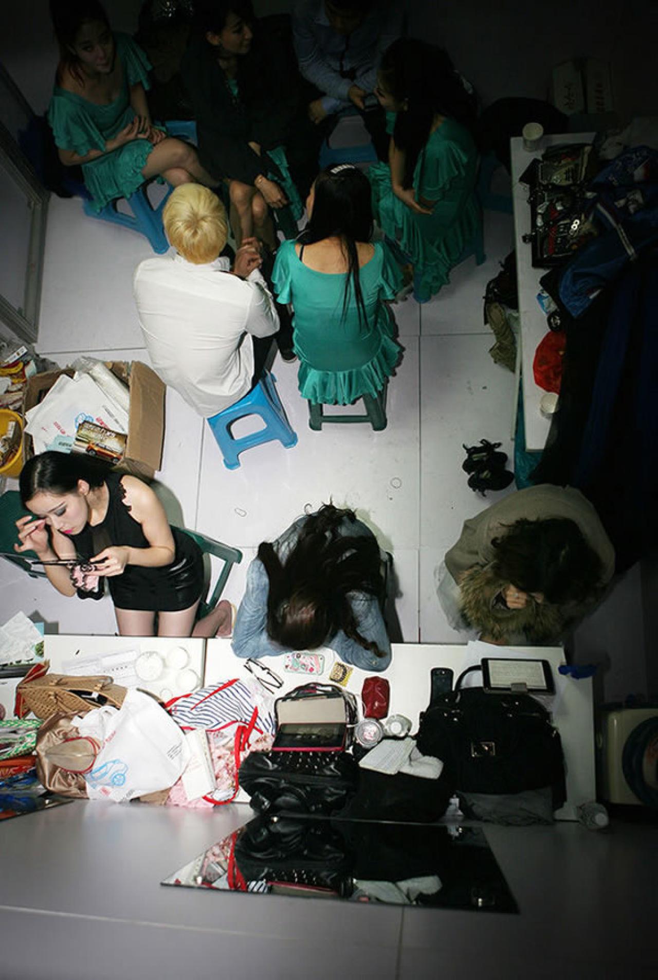 某展会杂乱拥挤的后台，Showgirl们挤在一起