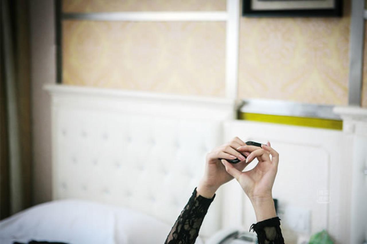 90后Showgirl王可欣双手握着手机举起时的特写