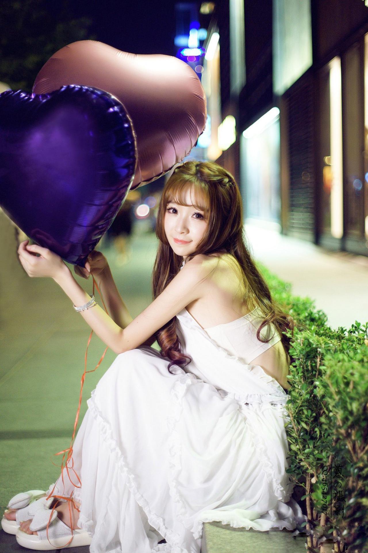 紫颜颜sweet坐在马路和人行道相间的台阶上