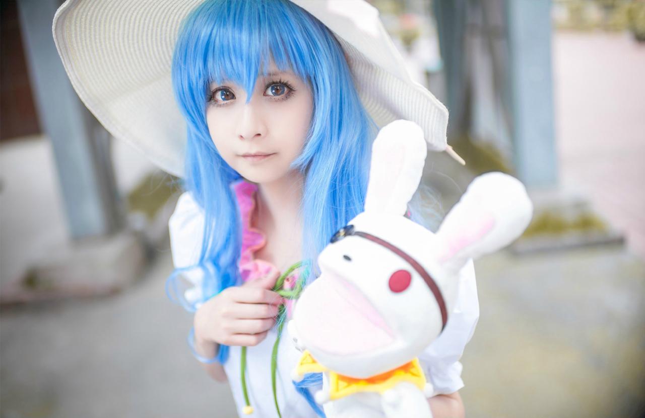 桃小陌扮演四糸乃拿着四糸奈兔子人偶，走在街上，上半身