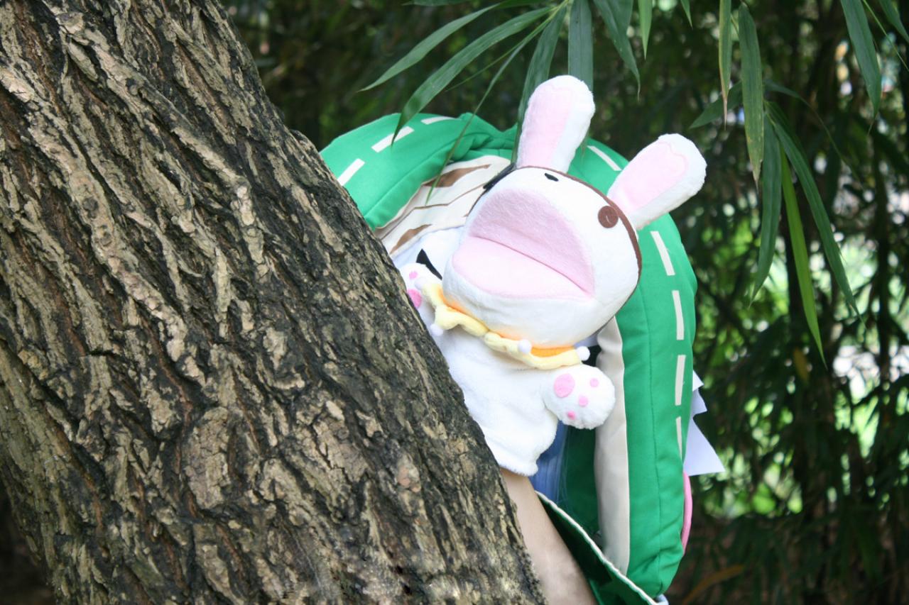 阡陌扮演四糸乃躲在树后，用玩偶四糸奈遮住自己的脸