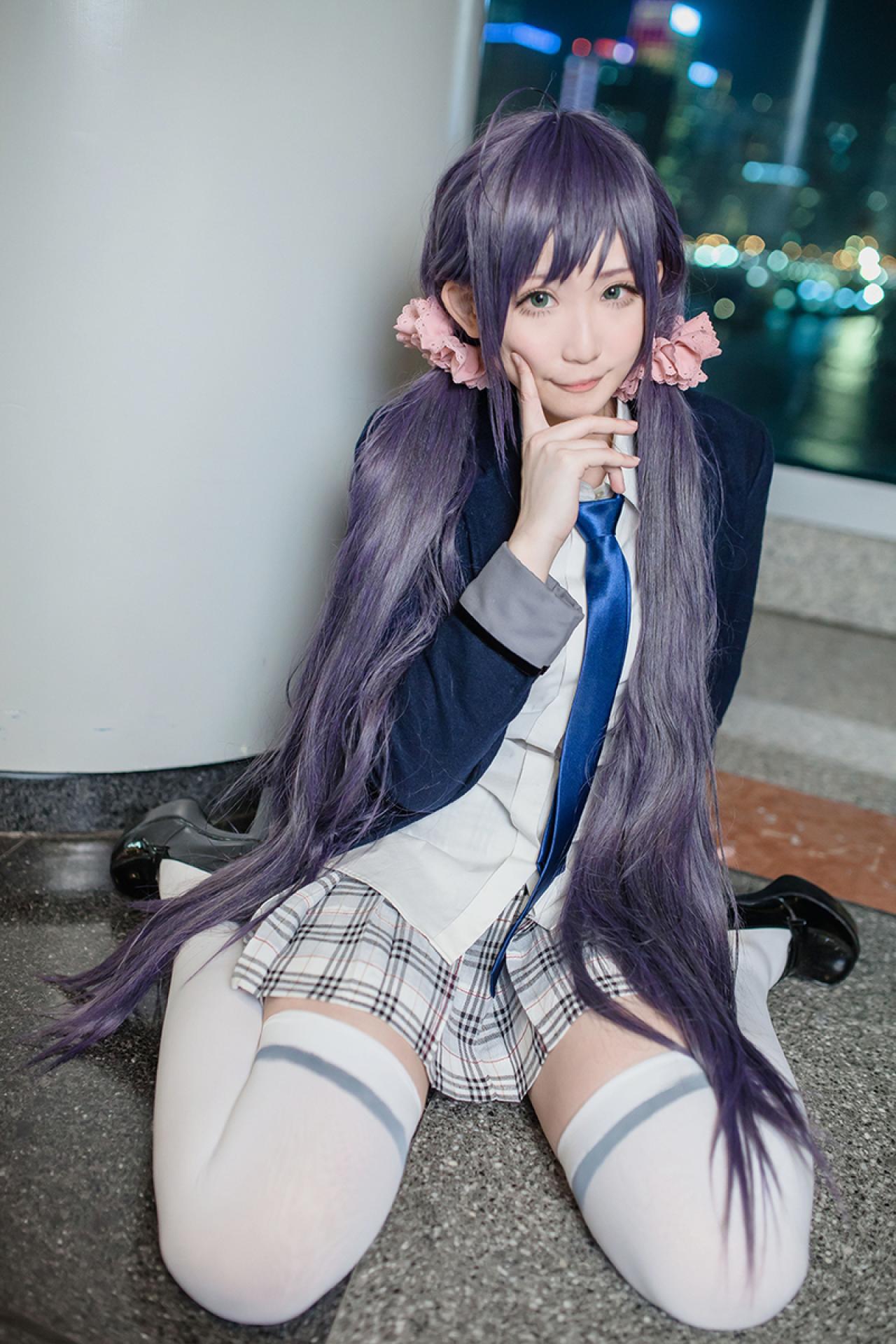 Kanda Laam扮演东条希跪坐在地上，手指按着脸颊嘟嘴卖萌的姿势