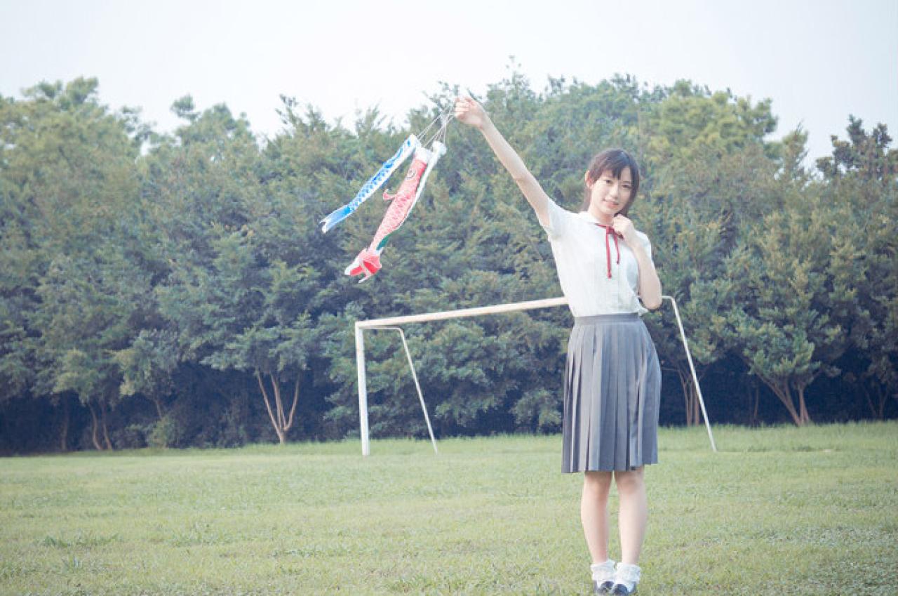 许夏幽拿着蓝色和红色鲤鱼旗，鲤鱼旗随风飞舞