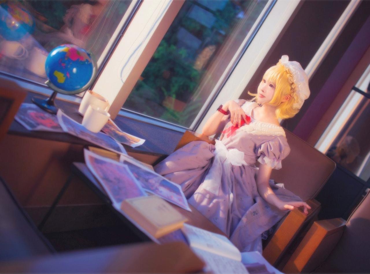 梅莉左手放在沙发，右手放在胸前，眺望窗外