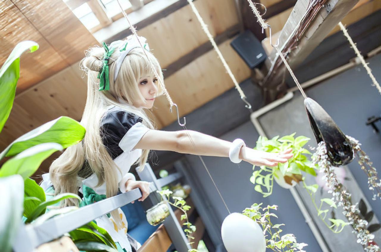 冰夜酱扮演南小鸟，身子探出阳台，用手去够吊着的各种花篮