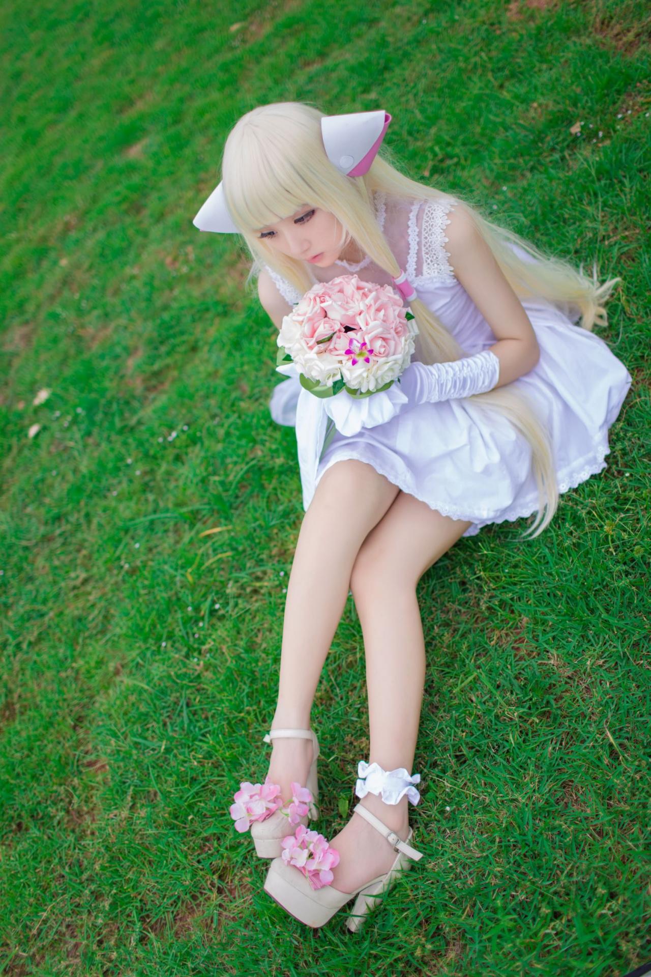 菌子扮演小叽端着手捧花伸展双腿，坐在草地上