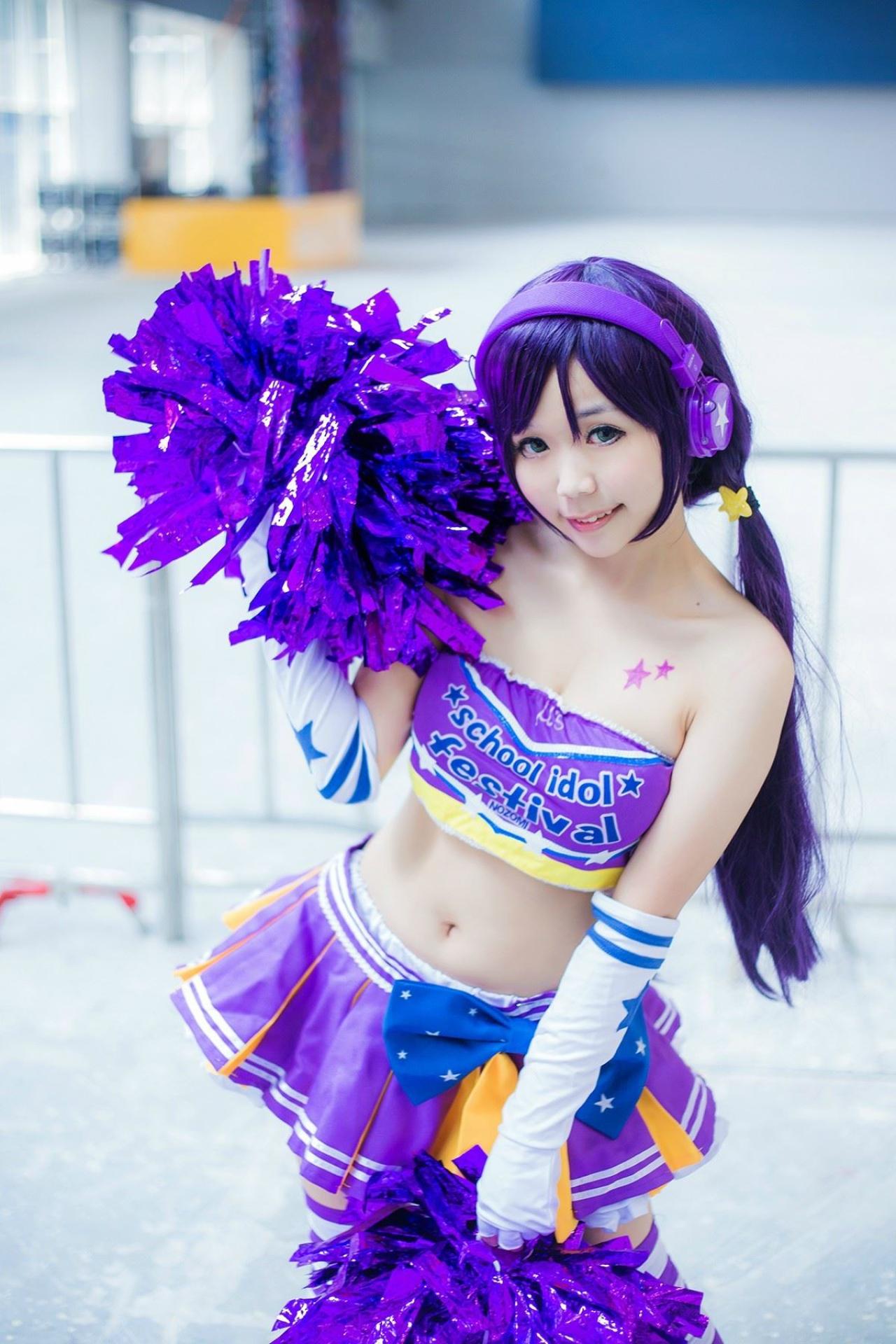 蓝天盈盈子扮演东条希一手将花球举起到肩部，一手自然下垂