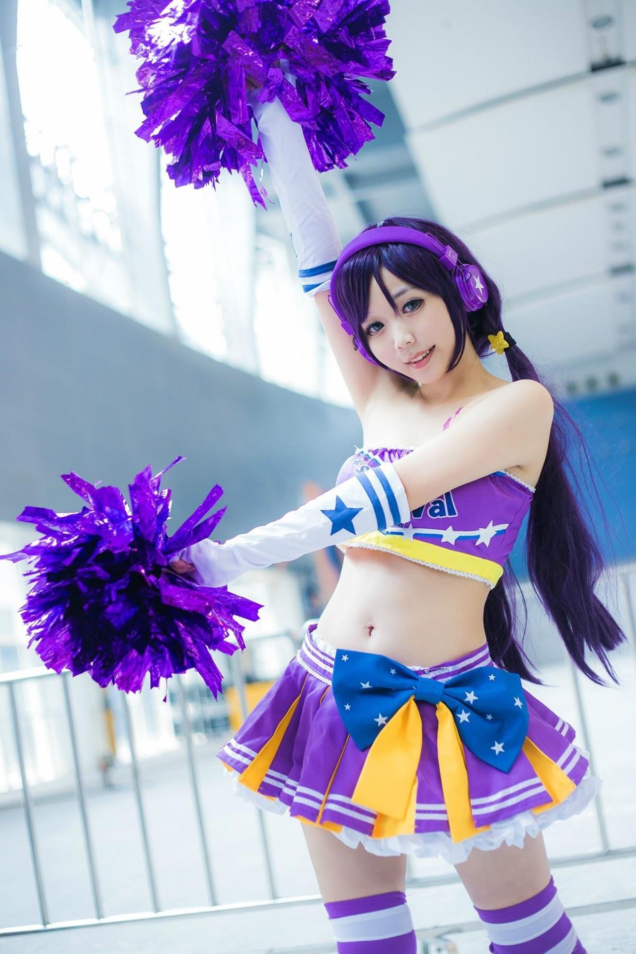 蓝天盈盈子扮演东条希右手抬起举着花球，左手平举拿着花球