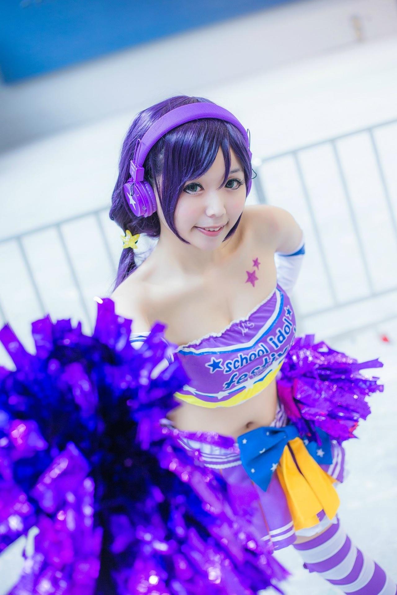 蓝天盈盈子扮演东条希左手背后，右手举着花球