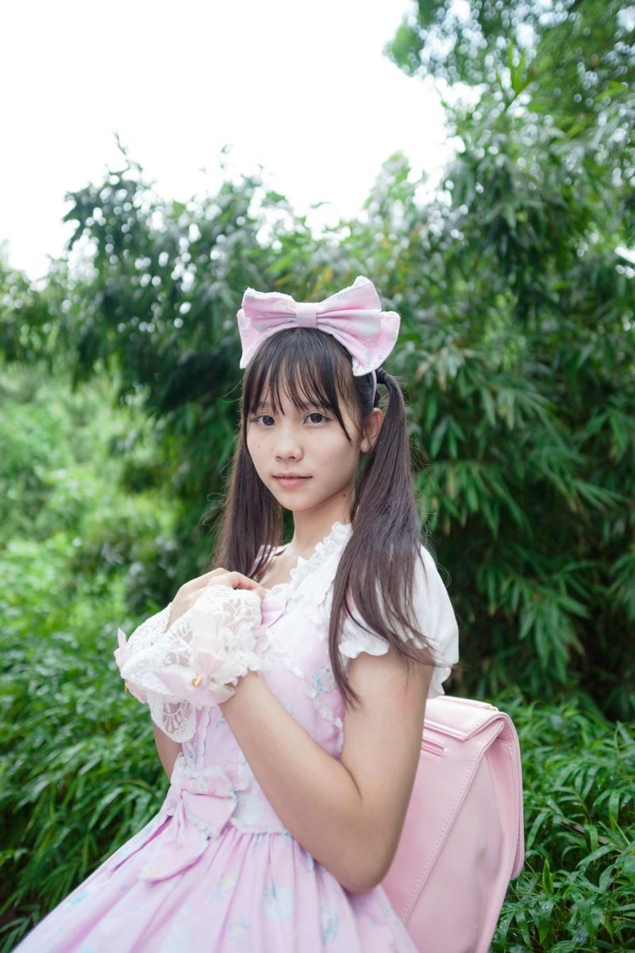 茶子双手叠放在胸前，背着粉色双肩背包