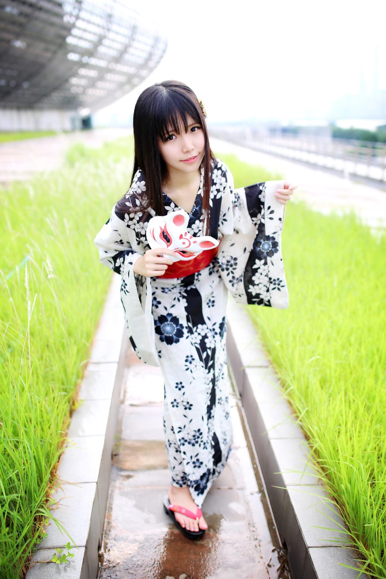 安姐姐拿着面具在草池中央卖萌姿势