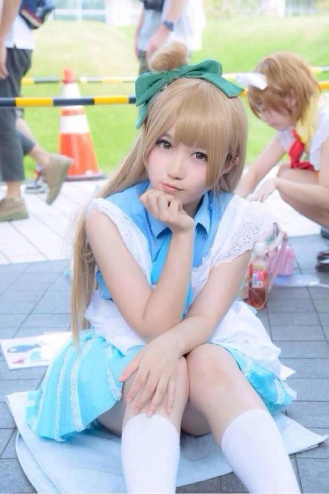 橘猫汰扮演南小鸟左手放在膝盖，右手轻轻抚摸下巴，歪着头的姿势