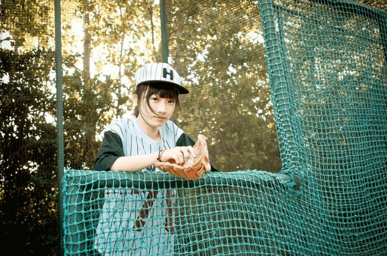 馋宝宝双手扶在棒球网上