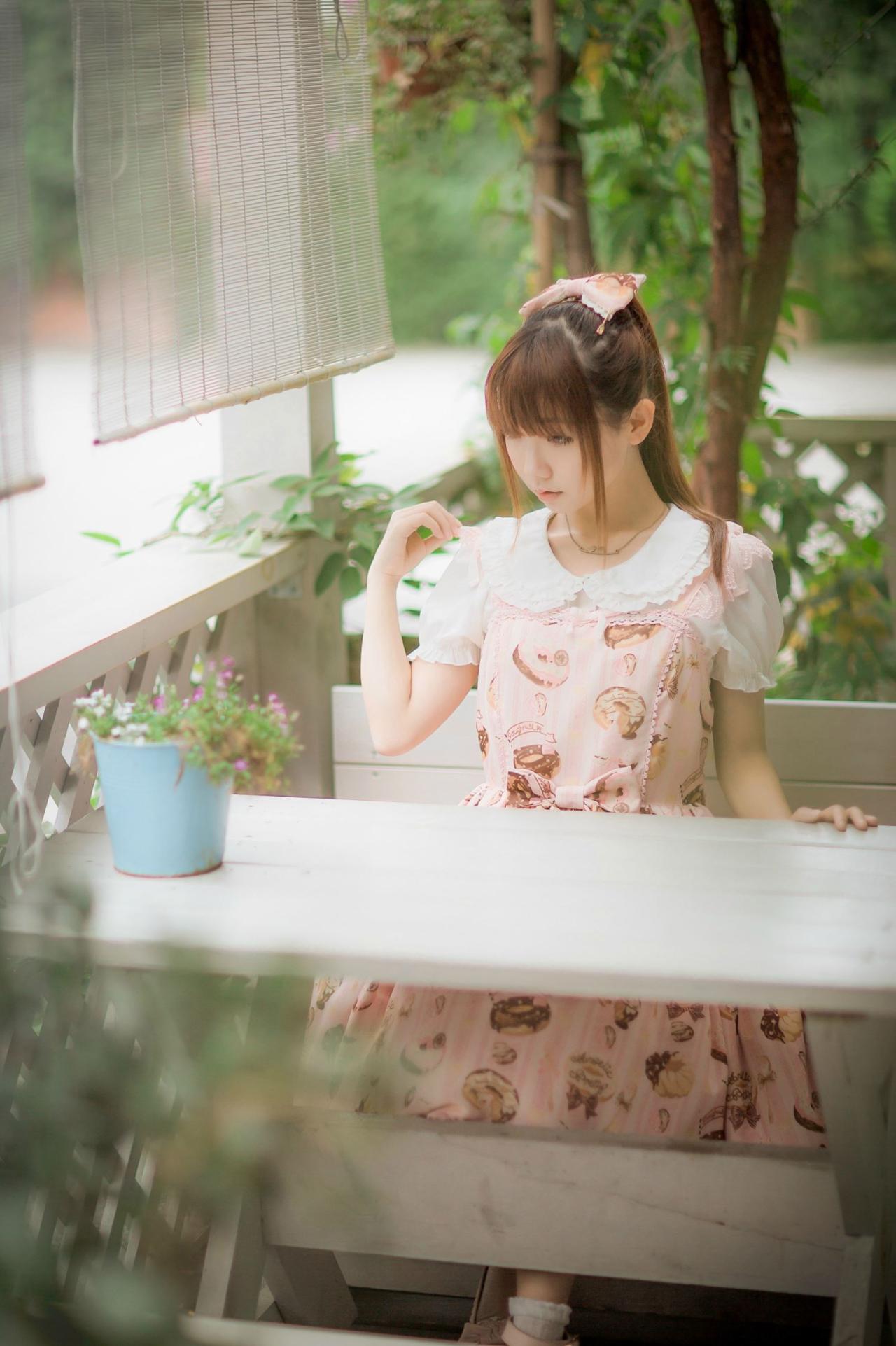 圆辛子坐在椅上傻瓜你，低头看着桌子上的一盆花