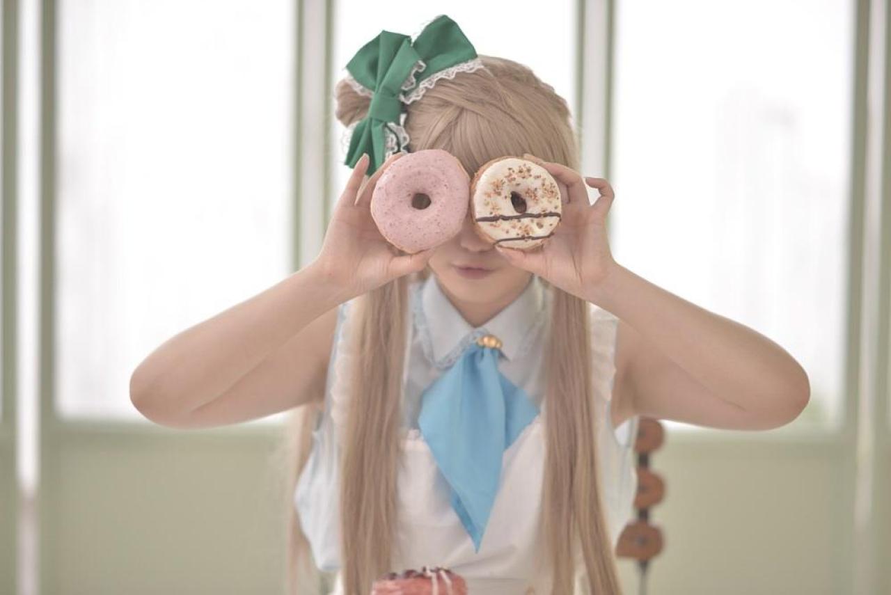 橘猫汰扮演南小鸟双手各拿一个面包圈，遮住眼睛，透过面包圈看世界