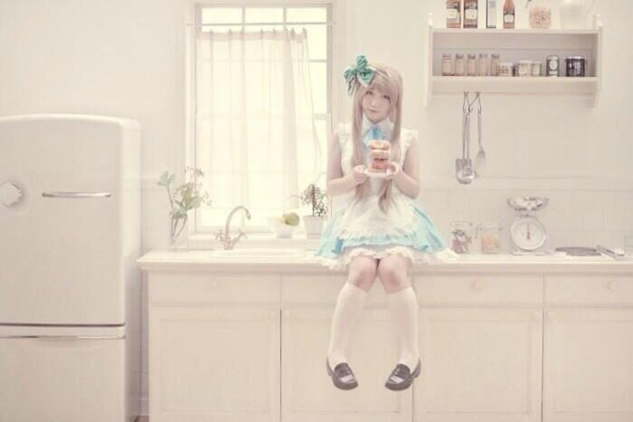 橘猫汰扮演南小鸟端着面包圈坐在橱柜上