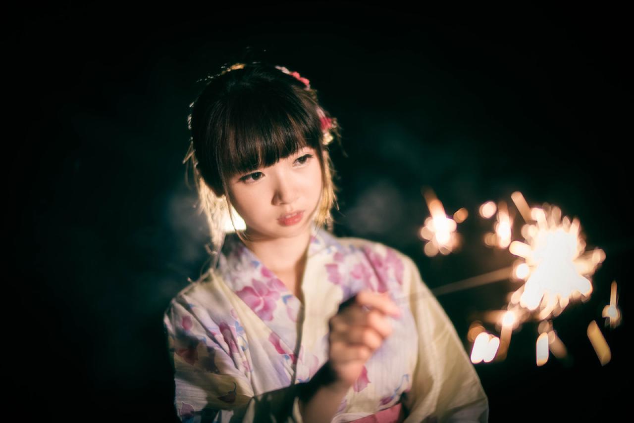 雪雪偏着头专注看着点燃的仙女棒