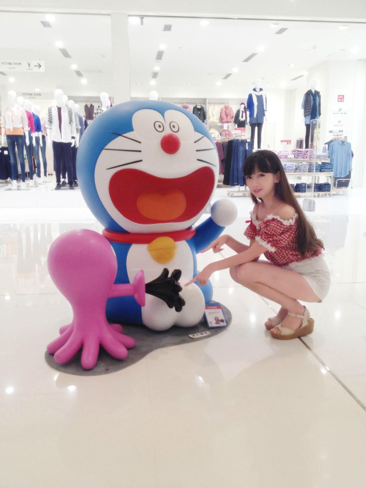 雪雪指着喷墨的小乌贼和张大嘴巴的哆啦A梦合影