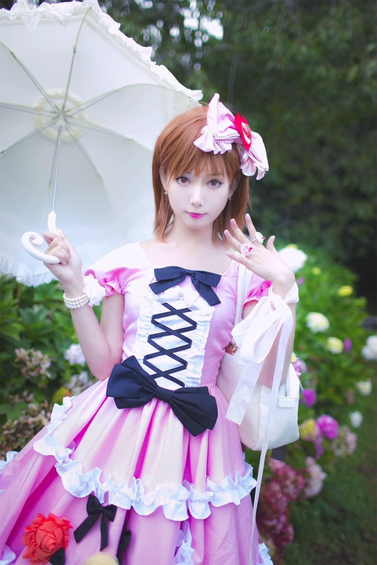 天海夜玖扮演御坂美琴右手撑着洋伞，左胳膊挎着包，手腕佩戴粉色丝巾