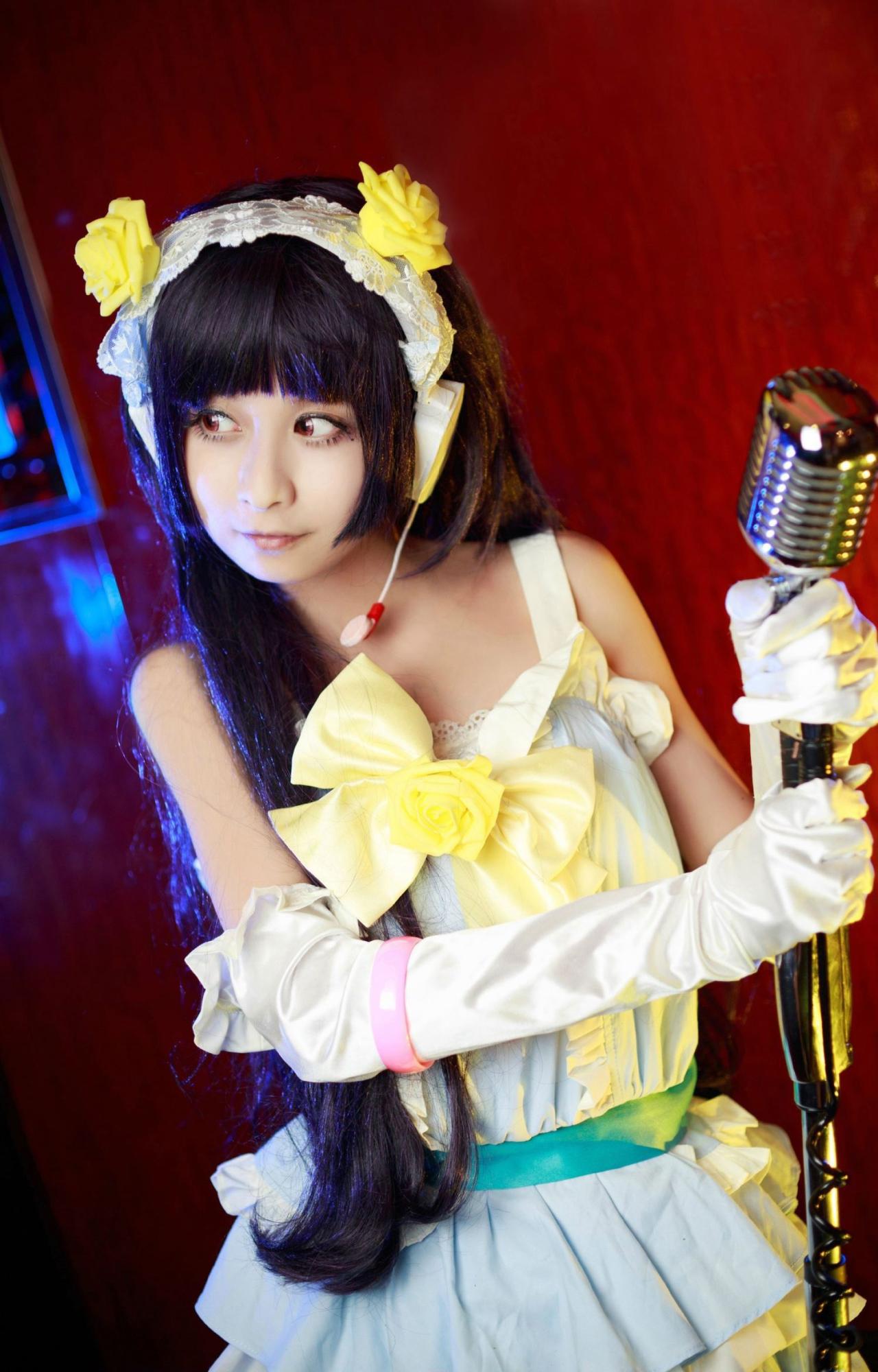 桃小陌扮演五更琉璃双手握着话筒，眼镜向右边撇去