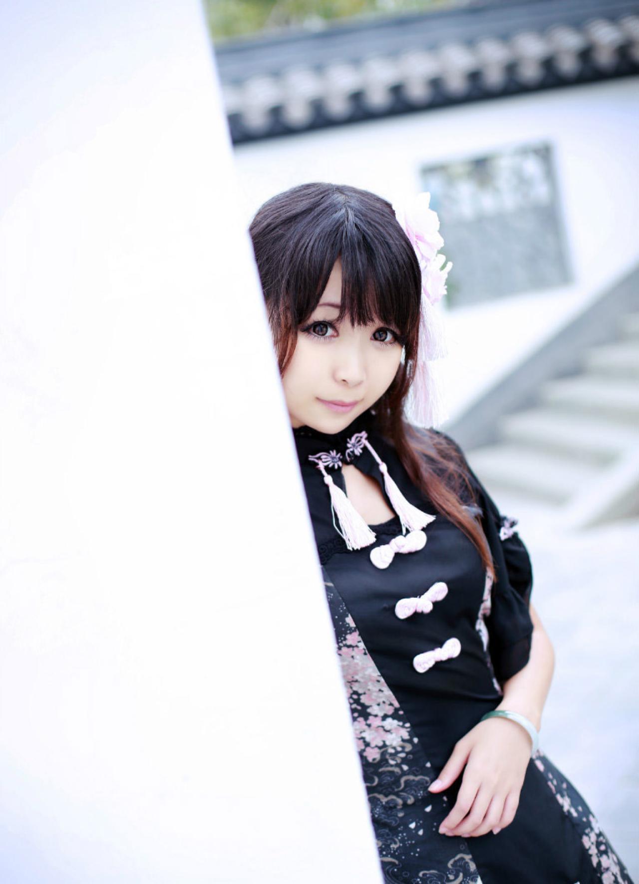 青梅素在白墙后，露出半边身子