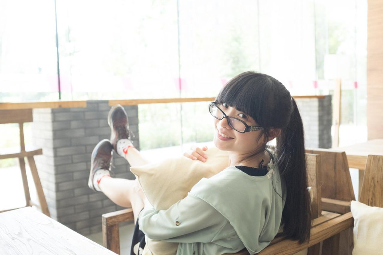 抱着枕头坐在椅子上回眸的萌妹子