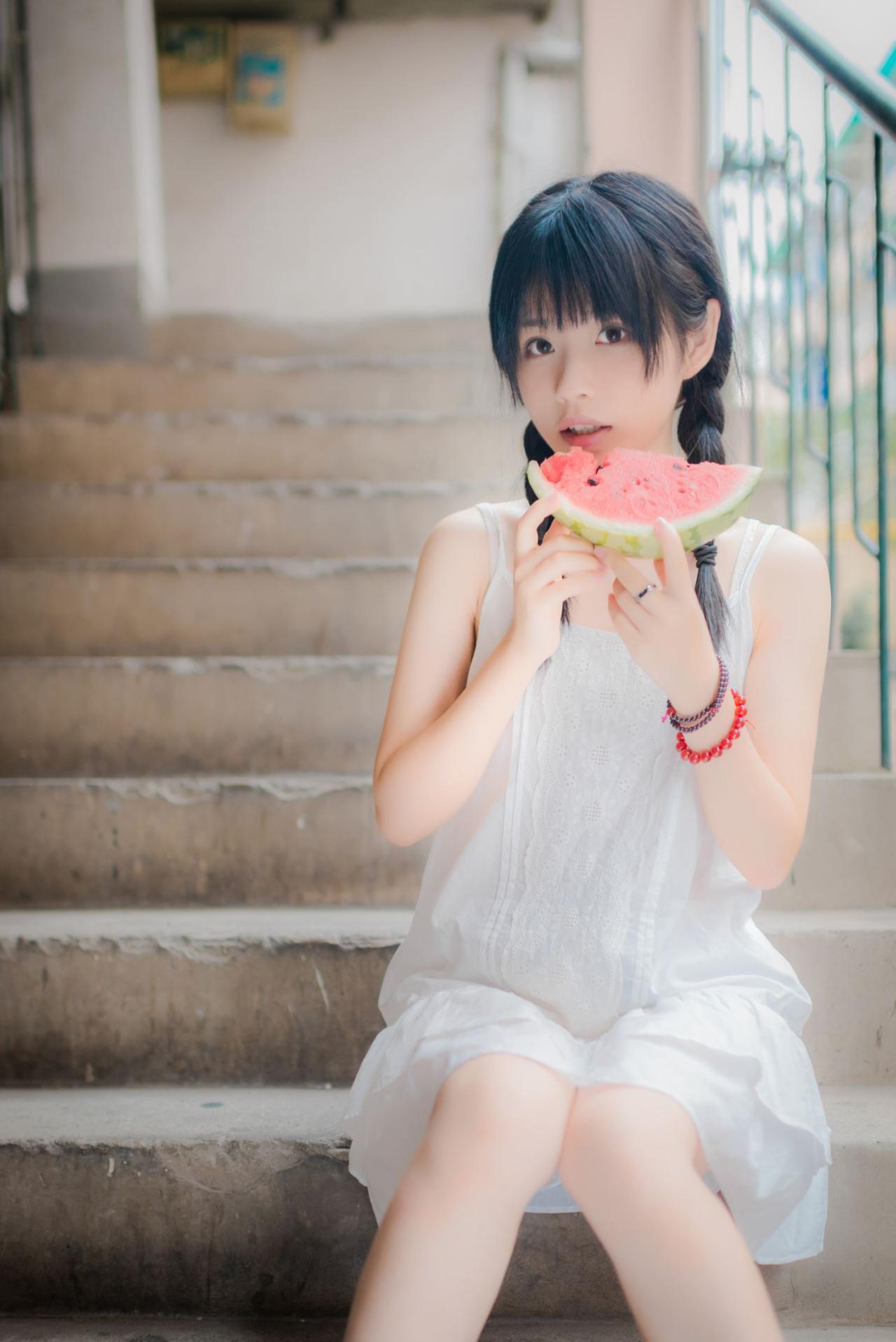 佐流端着咬了一口的西瓜，微微倾斜头看着镜头