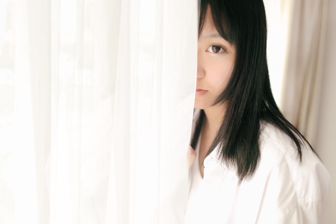 奈音蘑菇披着上衣，在窗帘后面露出半边脸