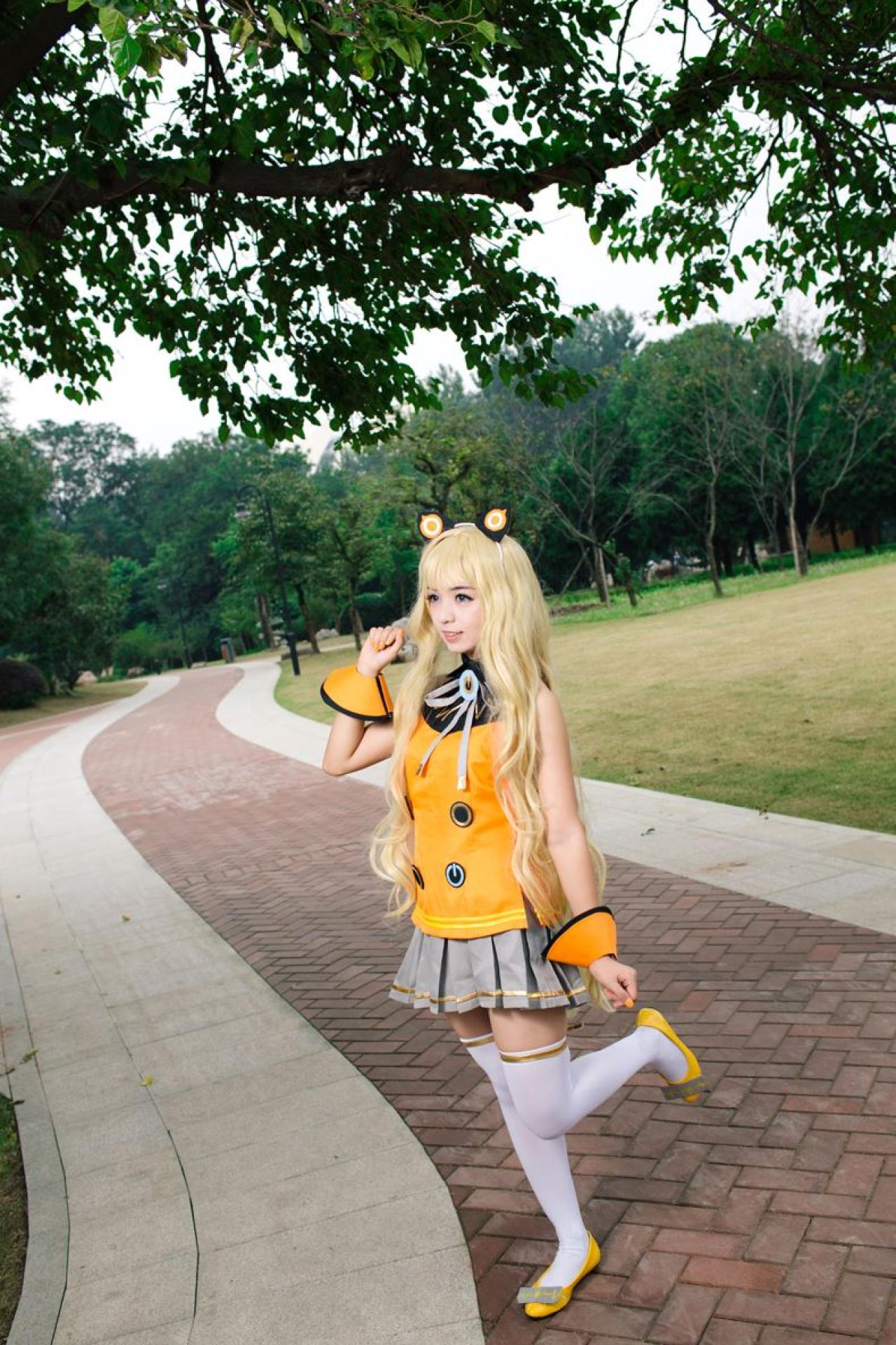 寻寻王扮演SeeU在绿荫小径上，右手半握拳举起侧面