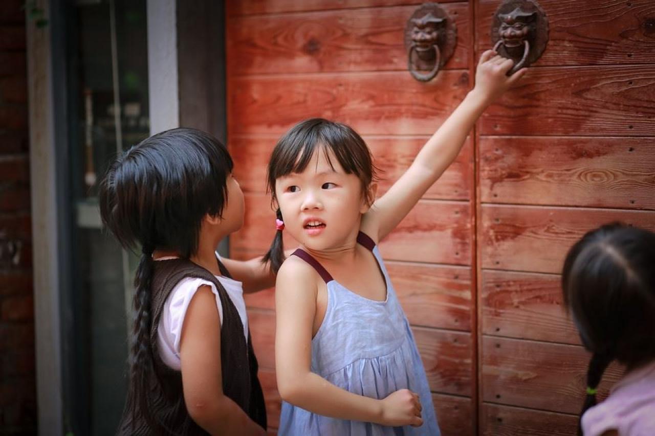 小女孩和她的小伙伴对门后面很好奇