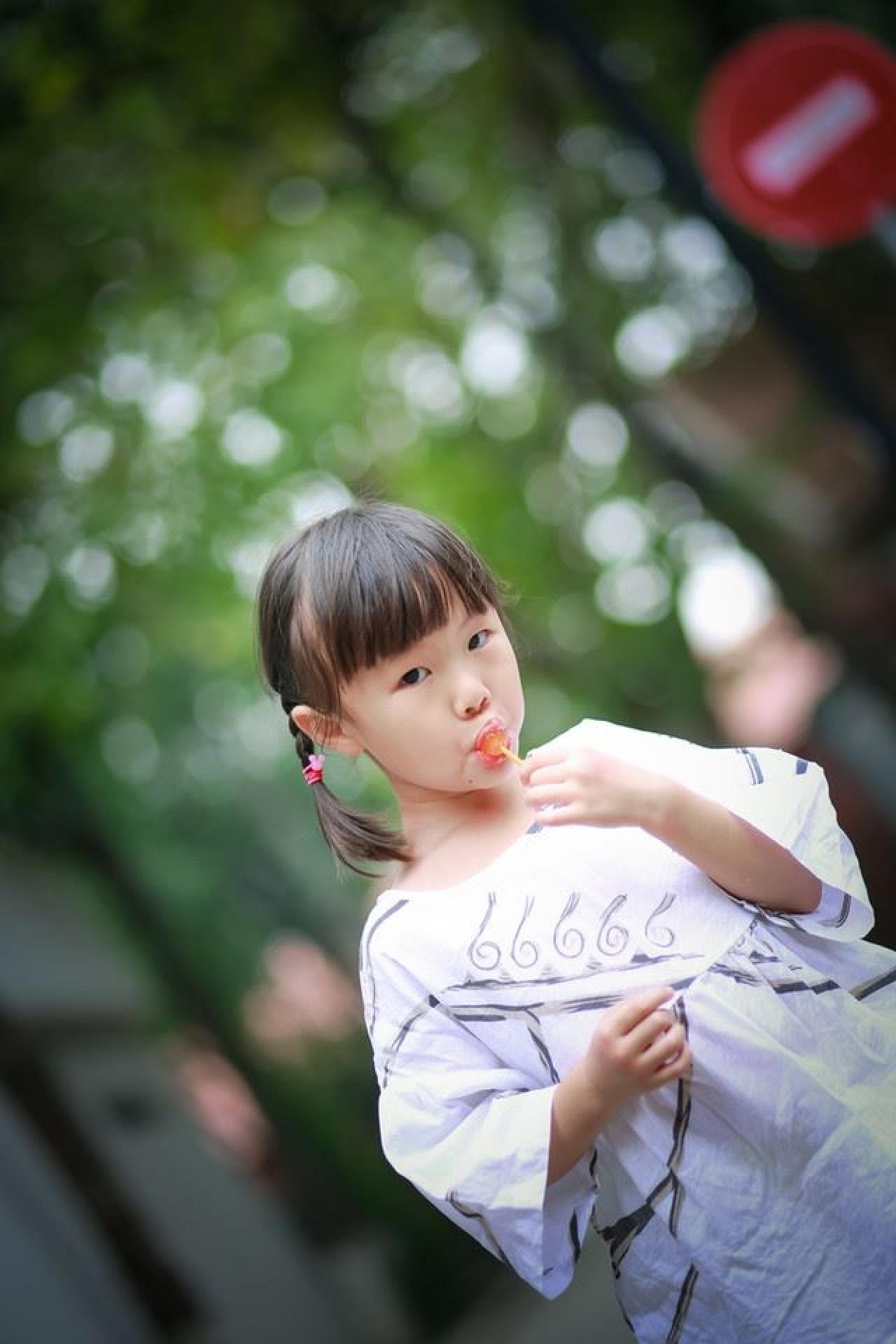 小女孩吃棒棒糖专注的神情