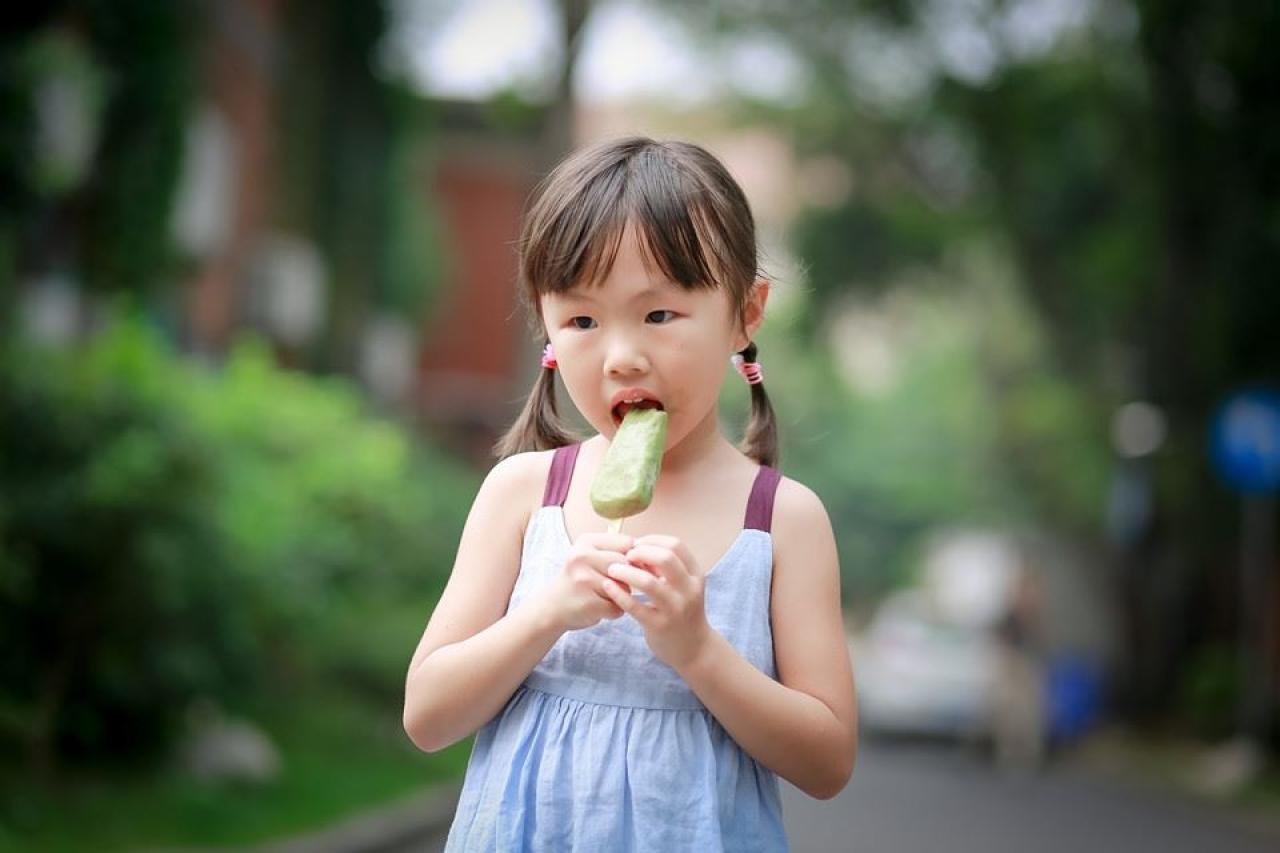 小女孩长大嘴巴吃绿豆雪糕的样子