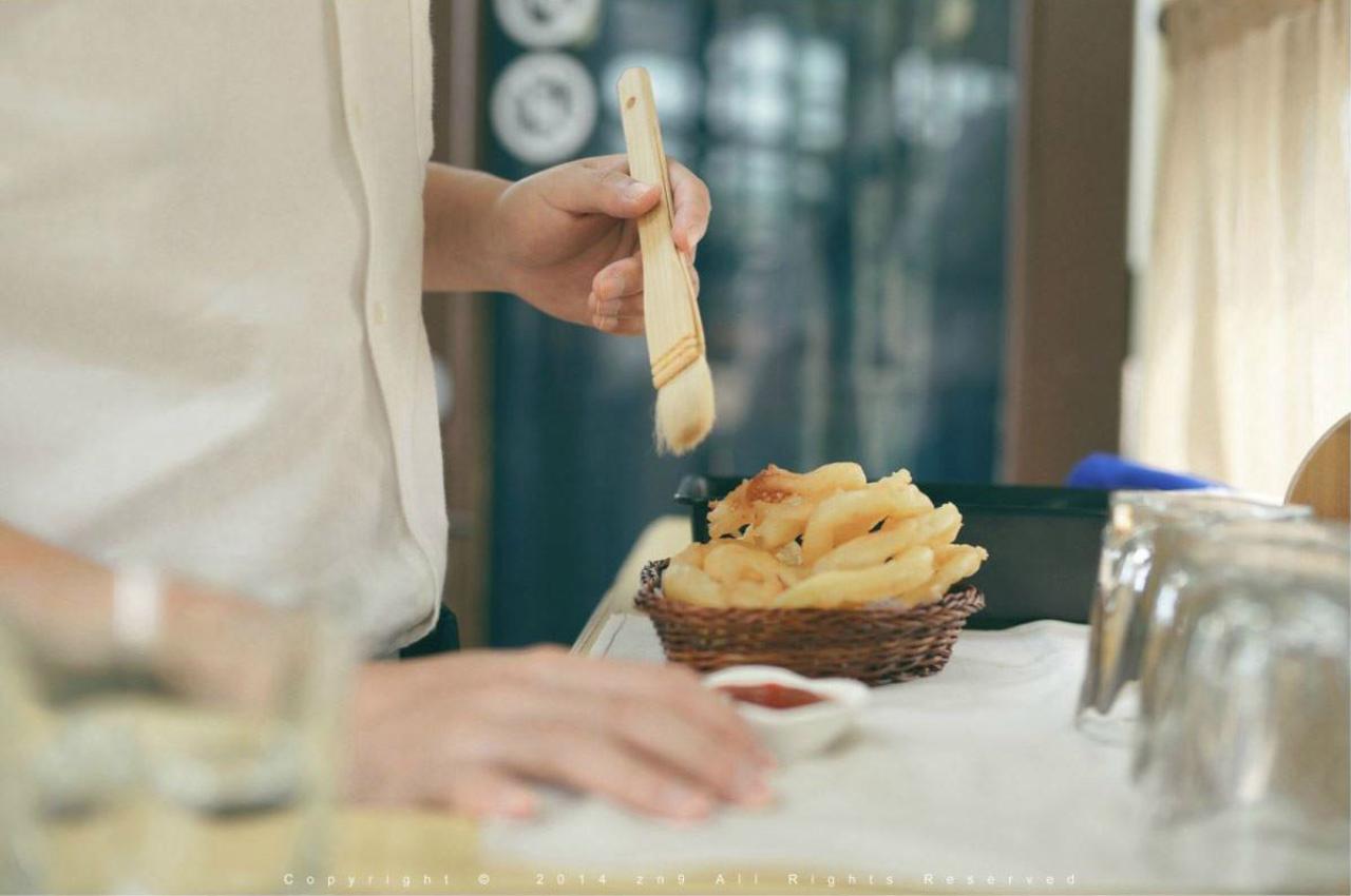 半个大叔正在给油炸圈抹番茄酱