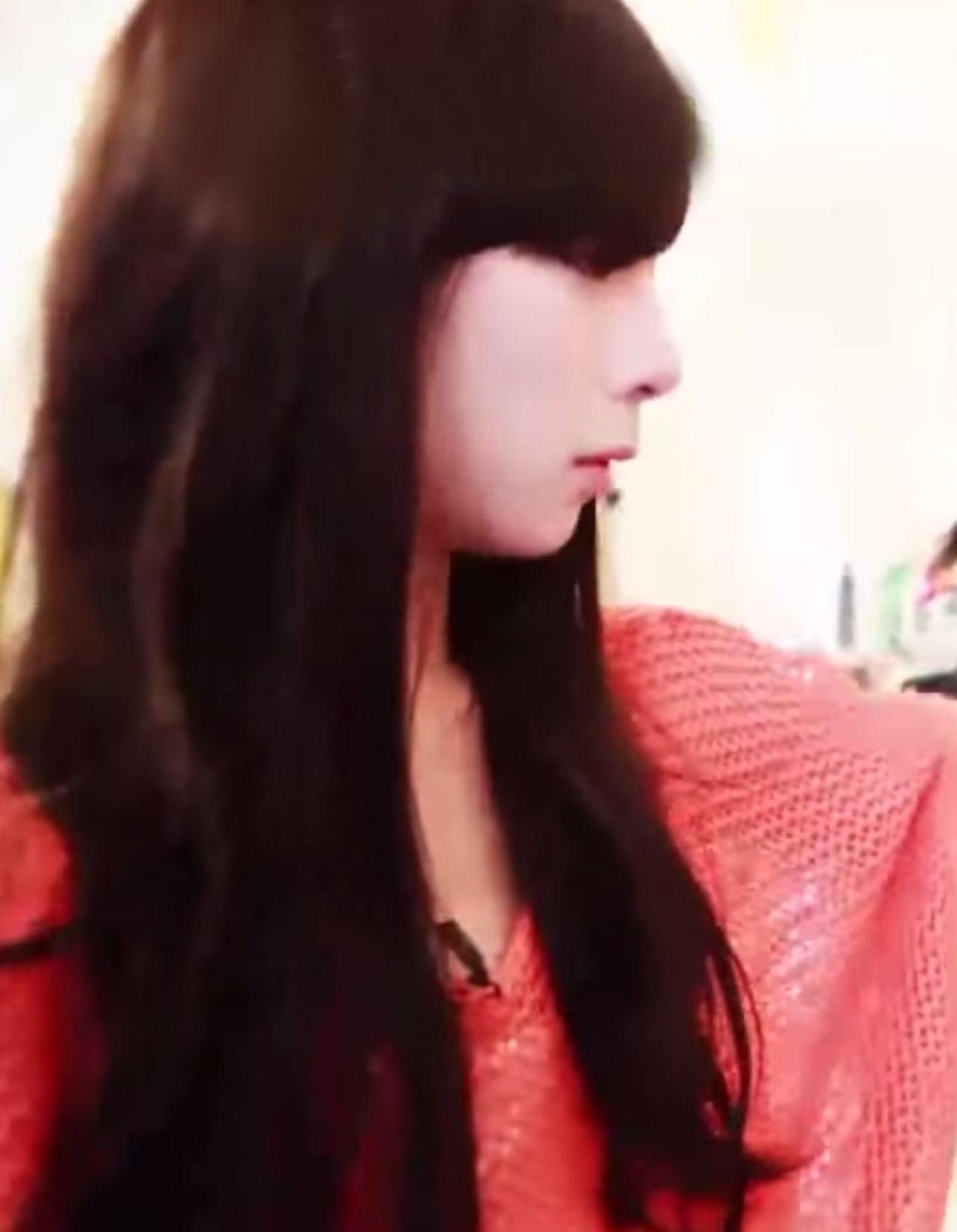 披着长发的男孩正在挑选衣服的侧脸