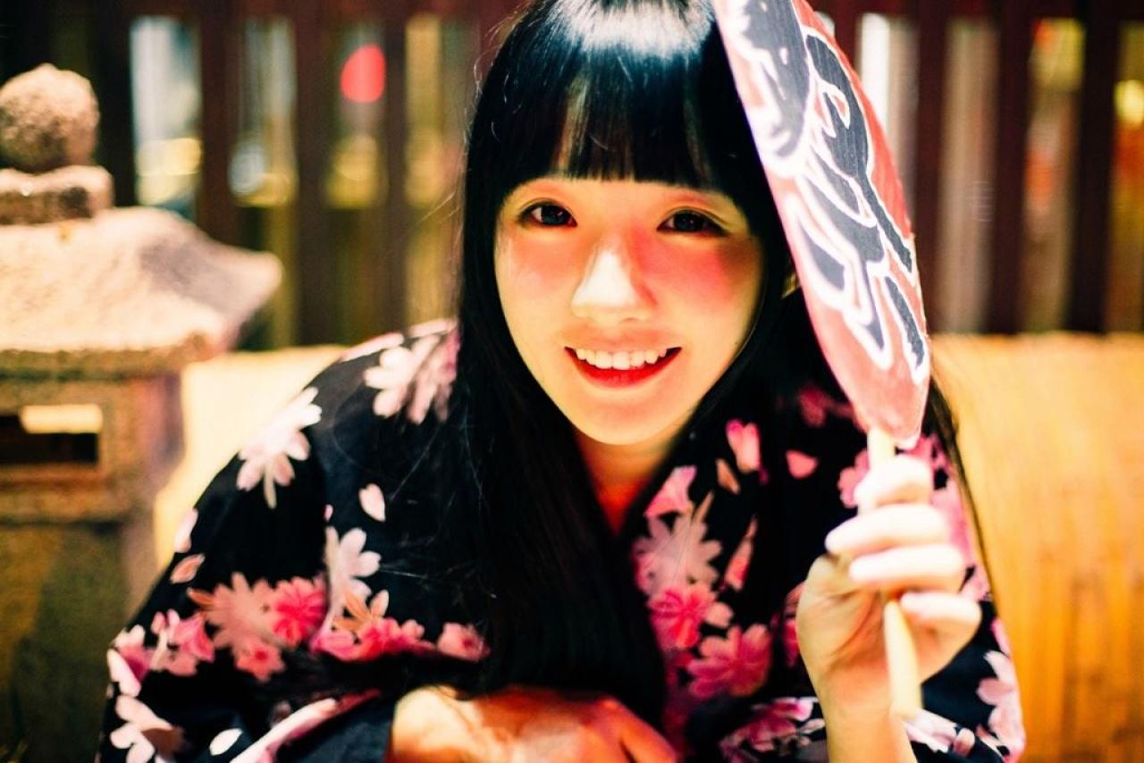 小陆离右手持扇贴着头发微笑