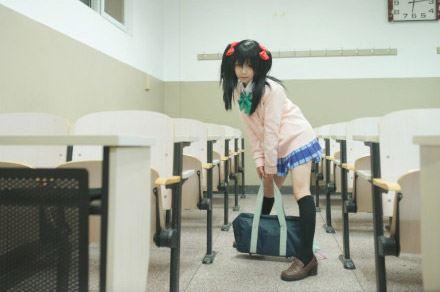 阿琴扮演矢泽妮可在过道双手提着包