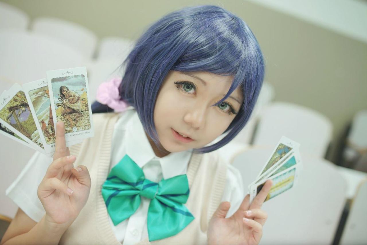 慕斯扮演东条希双手各捏着四张塔罗牌