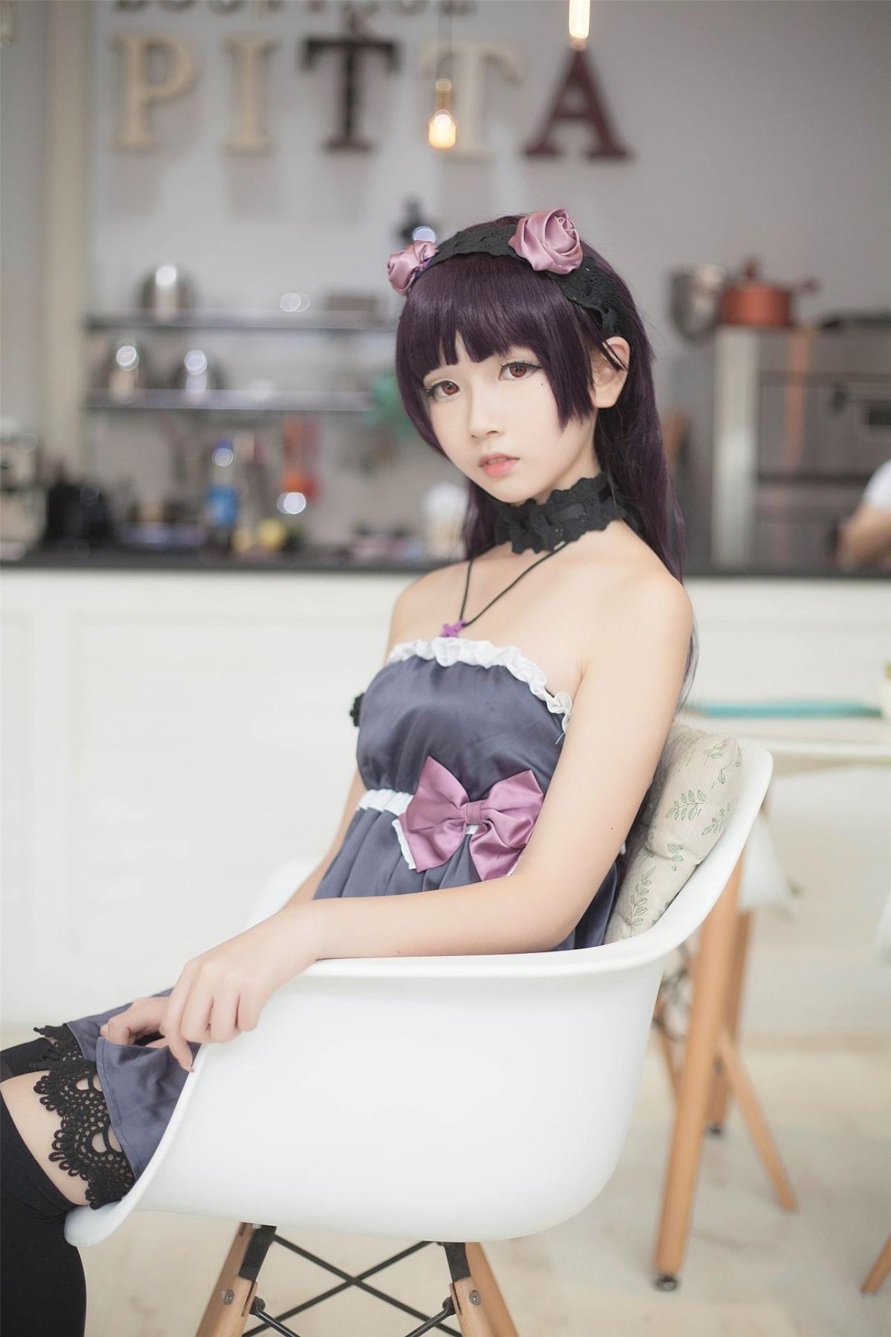 小圆脸雪雪扮演黑猫侧身坐在椅子上