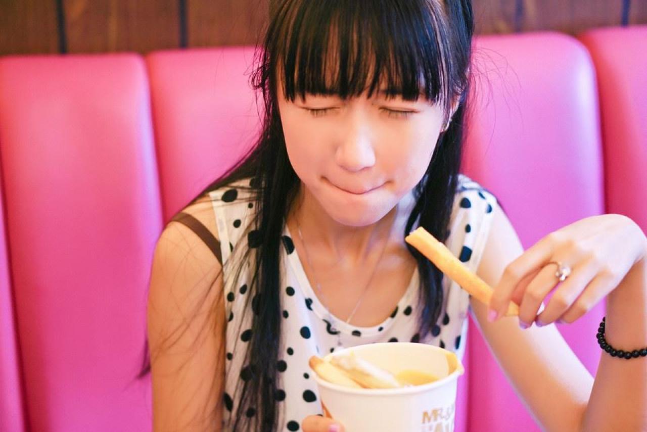 忧忧咬了一口薯条，回味无穷的神情