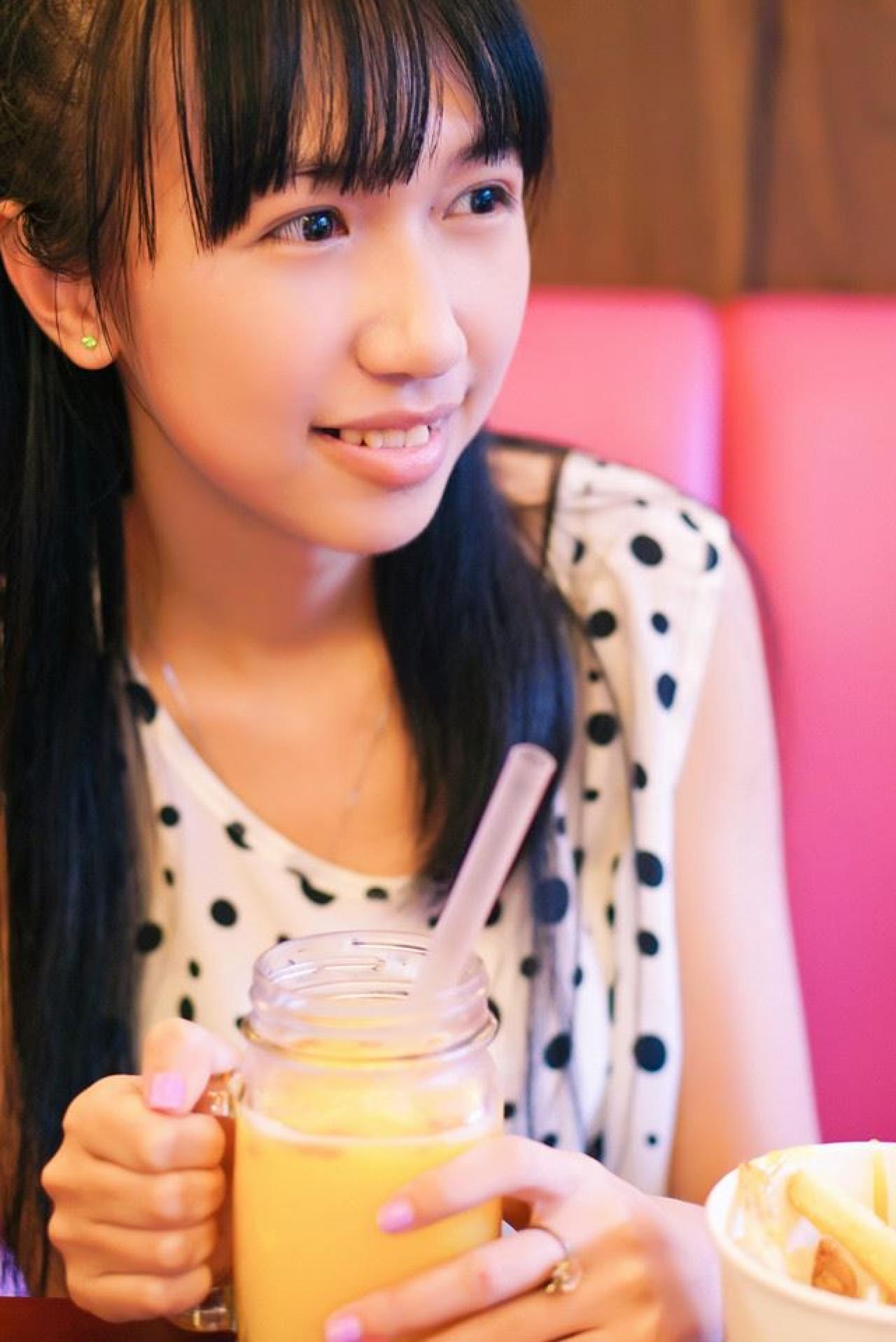 忧忧右手抓着杯把儿，左手扶着杯子，看向窗外