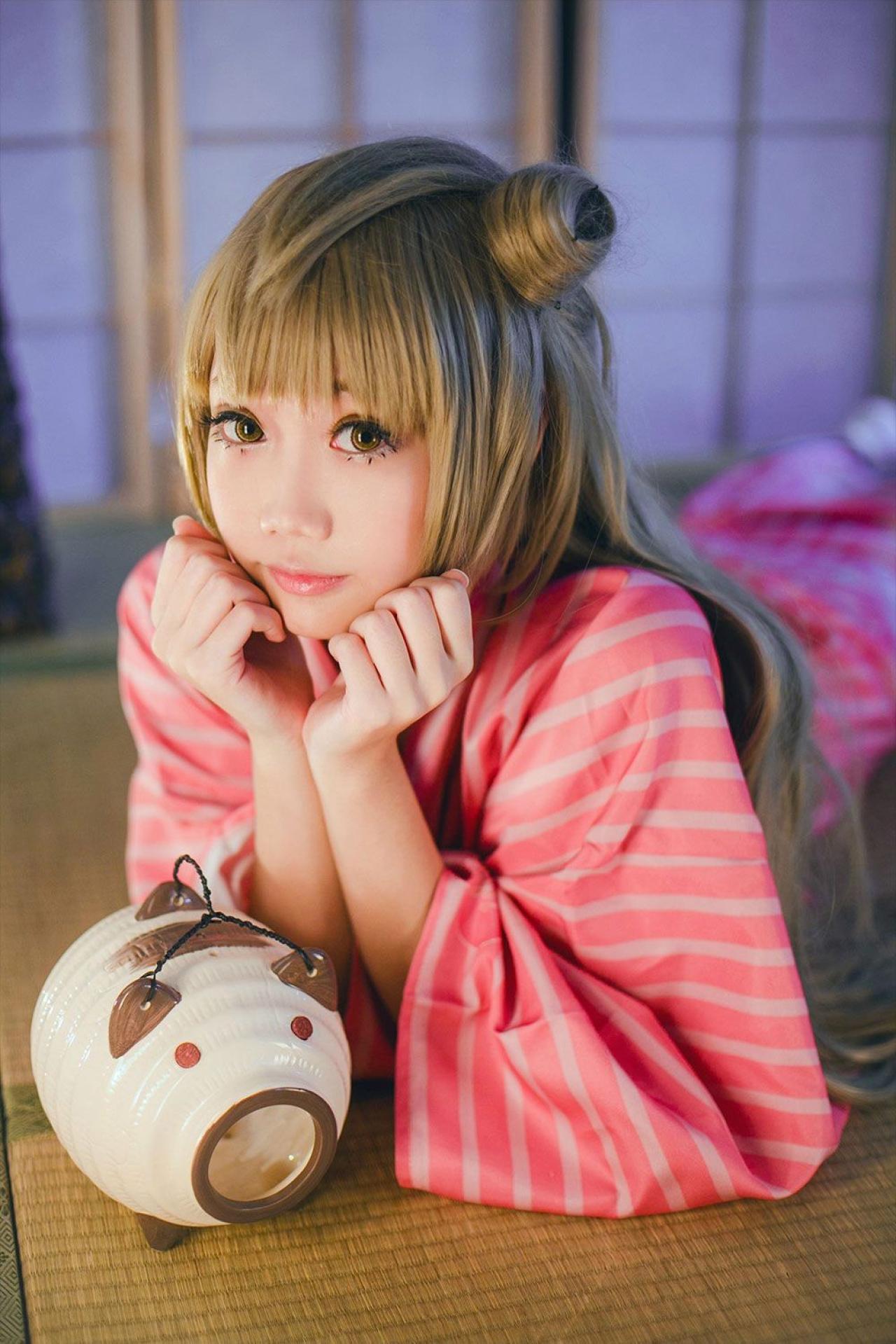 焖焖子扮演南小鸟双手撑着脸趴在席子上，双手前放着小猪香炉