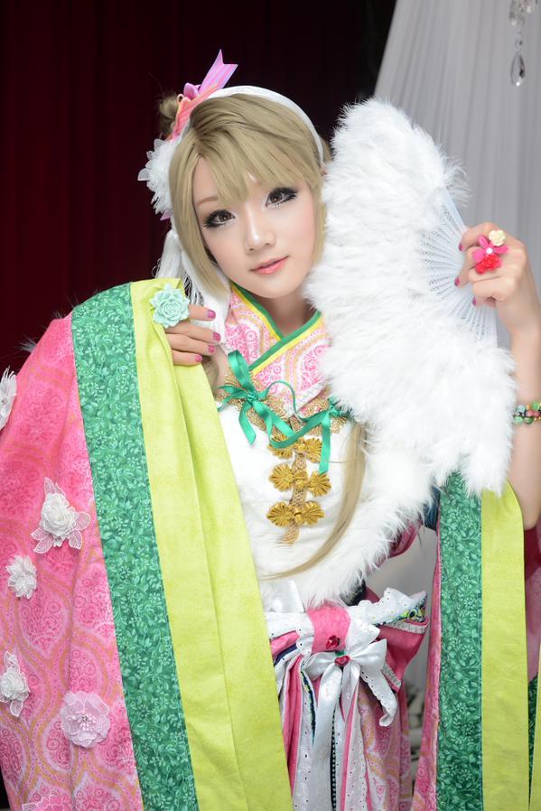 Miyuko扮演南小鸟左手持扇，扇叶贴在脸颊上