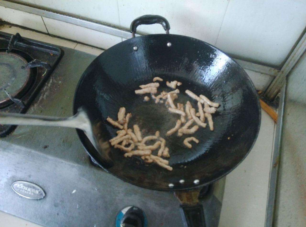 第五步，向锅中倒入肉丝，迅速翻炒